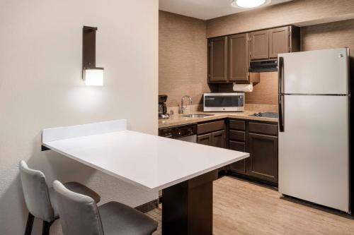 a kitchen with a white table and a refrigerator at Residence Inn Denver Southwest/Lakewood in Lakewood