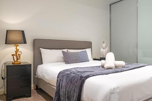 a bedroom with a large white bed with a blue blanket at Modern Urban Retreat 1BR Apt near Chatswood in Sydney