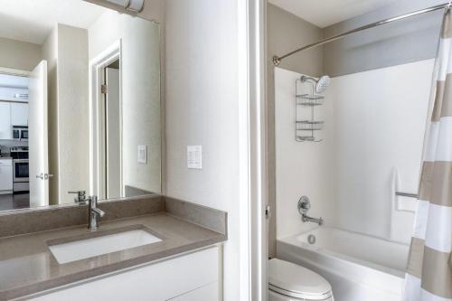 ein Badezimmer mit Waschbecken, Toilette und Spiegel in der Unterkunft Sunnyvale 1br w gym spa pool nr tech SFO-1443 in Sunnyvale