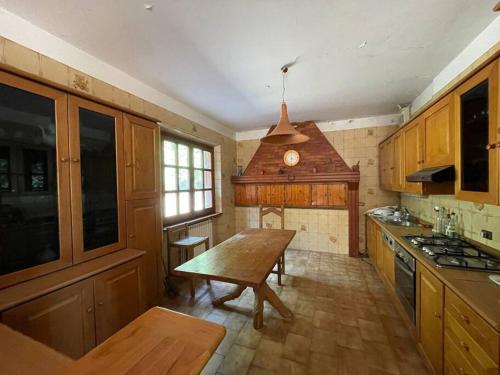 a kitchen with wooden cabinets and a wooden table at Casa dei nonni in Alba Adriatica