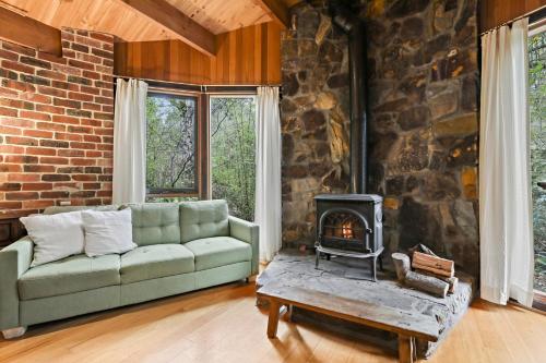 uma sala de estar com um sofá e uma lareira em Birch Suite - Rocky Creek Art Garden em Olinda