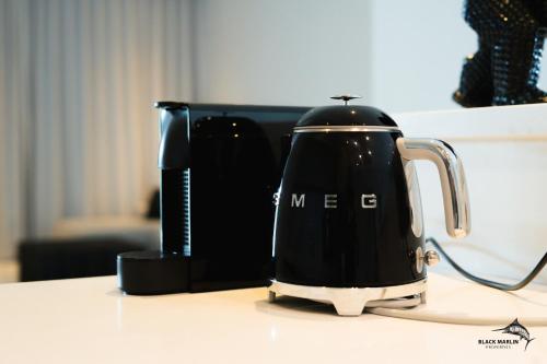 a black tea kettle sitting on a counter at Black Marlin Apartments in Pereybere