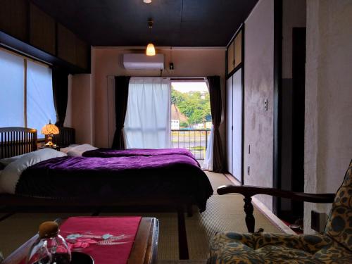 a bedroom with a purple bed and a window at 酒と宿と不動産-yado- in Yokosuka