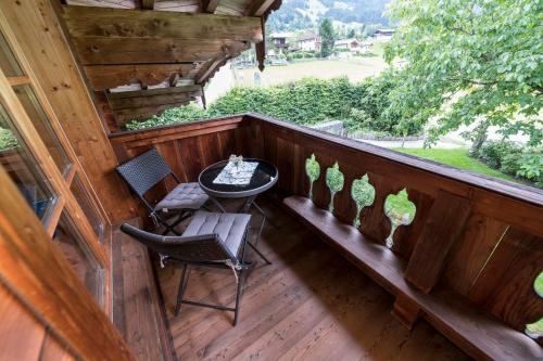 a balcony of a cabin with a table and chairs at Apartment Nussbaum in Jochberg