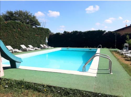 a large swimming pool with a slide in a yard at AC Ranch in Carentino
