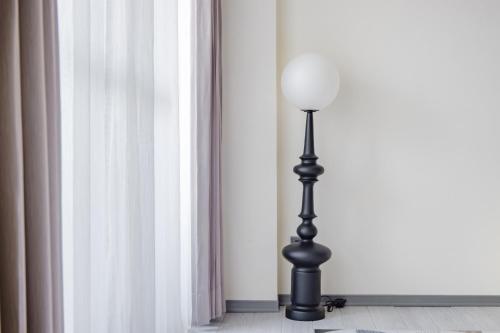 a black pole with a white lamp in a room at Long Stay Here in Tainan