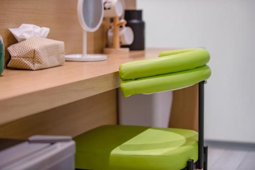 a green chair sitting in front of a desk at Long Stay Here in Tainan
