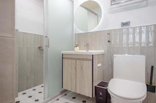 a bathroom with a toilet and a sink and a mirror at Long Stay Here in Tainan