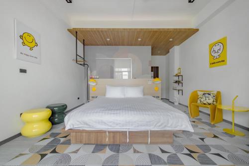a bedroom with a bed and a yellow chair at Long Stay Here in Tainan