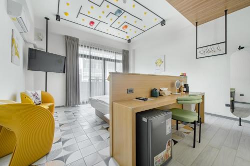 a room with a bed and a desk and chairs at Long Stay Here in Tainan