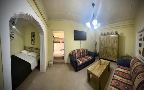 a bedroom with a bed and a couch and a chair at Panorama rooms in Chios
