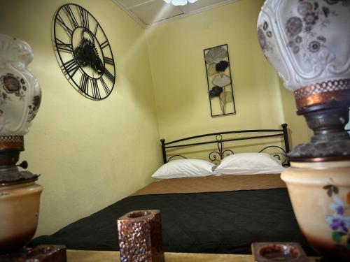 a bedroom with a bed and a clock on the wall at Panorama rooms in Chios