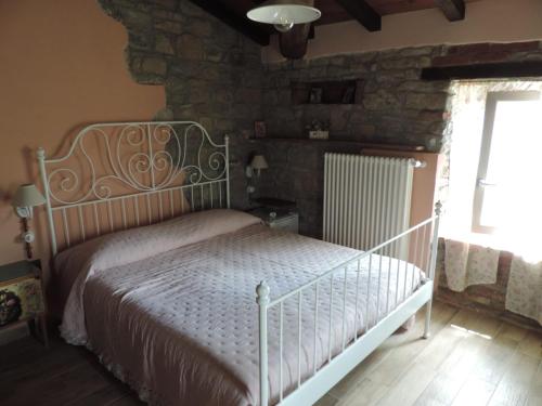 a bedroom with a bed and a stone wall at B&B La Rocchetta dal Sròz in Le Serucce