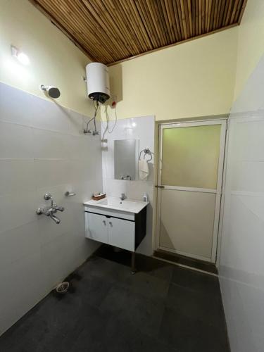 a bathroom with a shower and a sink and a mirror at Manas Jungle Retreat in Jyoti Gaon