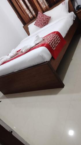 Cama en habitación con marco de madera en RD HOTEL en Erode