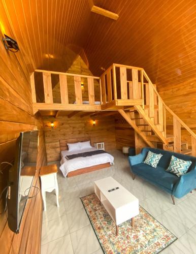 Godieng Cabin 2 في Diyeng: غرفة نوم في كابينة خشب بها سرير وسلالم