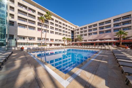 a swimming pool in front of a building at Estival Park Almaris in La Pineda