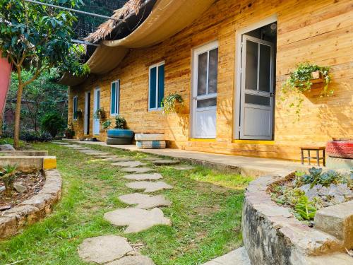 ein Haus mit einem Steinweg davor in der Unterkunft Mộc House in Mộc Châu