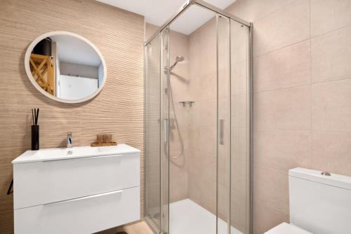 Un baño con ducha, lavabo y espejo. en Real de Ifach - Atico, en Empedrola