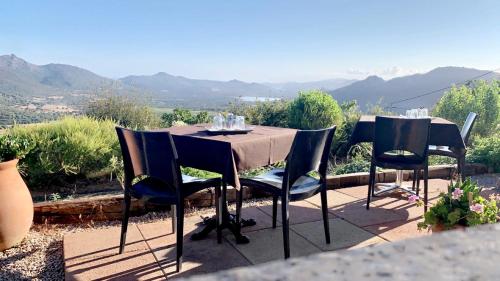 a table and chairs with a view of the mountains at La Roulotte U Sognu in Muro