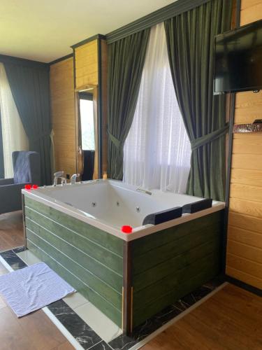 uma grande banheira num quarto com uma janela em SoOnSuitApart em Çamlıhemşin
