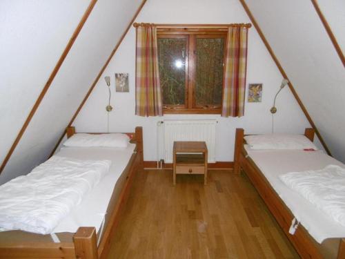 two beds in a small room with a window at Twistesee 36 in Bad Arolsen