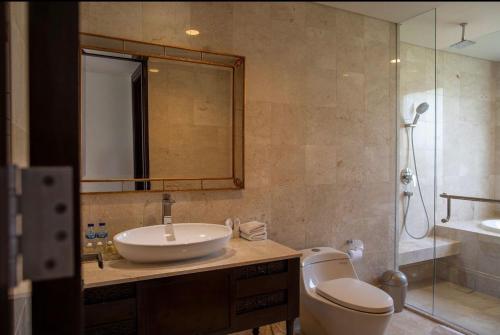 a bathroom with a sink and a toilet and a shower at Luxury Apartment at AYANA Residences in Jimbaran