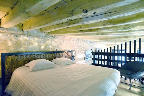 une chambre avec un grand lit et une chaise dans l'établissement Galerie - Ancienne galerie de peinture sur le port, à Dinan