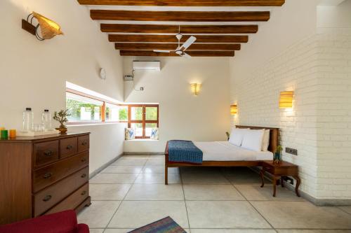 une chambre avec un lit et une commode dans l'établissement amã Stays & Trails Forest Home, Hosur, à Hosur