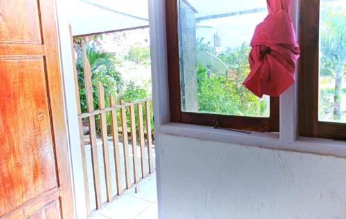 Rocky homestay lakey nangas beach في Huu: نافذة بها منشفة حمراء معلقة منها