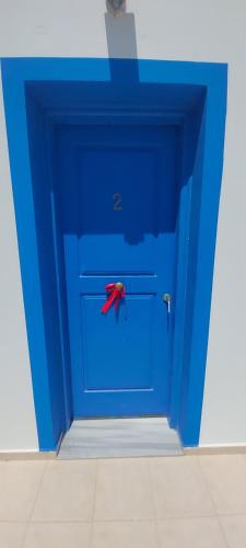 a blue door with a red object on it at Vigles in Adamas