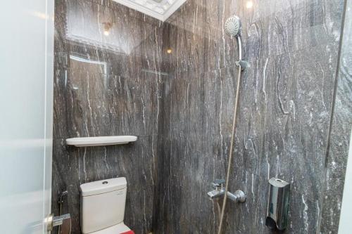 a bathroom with a shower and a toilet in it at Urbanview Hotel Sultan Palace Malang by RedDoorz in Dau