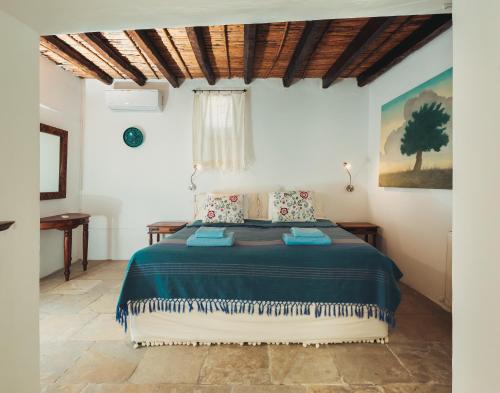 1 dormitorio con 1 cama grande con sábanas azules en Archondia House - Holiday Apartments With Pool, en Kalavasos