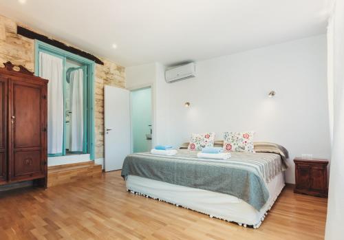 1 dormitorio con 1 cama y suelo de madera en Archondia House - Holiday Apartments With Pool, en Kalavasos