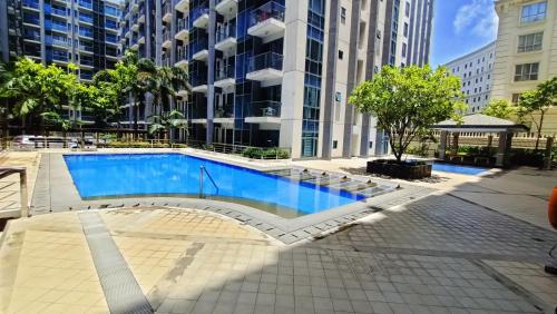 uma piscina em frente a um edifício alto em Hilanders Condotel Across Terminal 3 em Manila