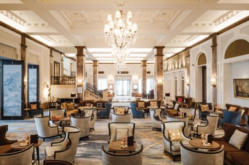 a hotel lobby with chairs and tables and a chandelier at Hotel Atlantic Hamburg, Autograph Collection in Hamburg