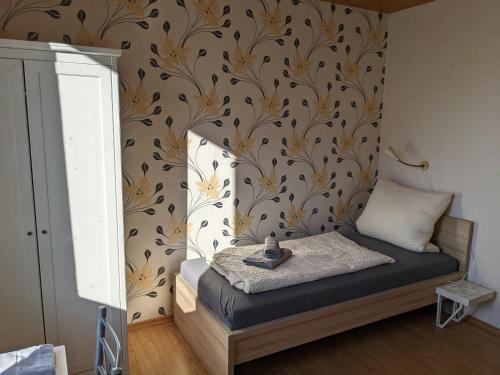 a bedroom with a bed with a flowery wallpaper at Monteurunterkunft Weiden by HausGruenerBaum in Weiden