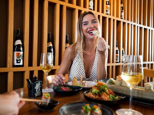 a woman sitting at a table eating food at Fairmont Bab Al Bahr in Abu Dhabi