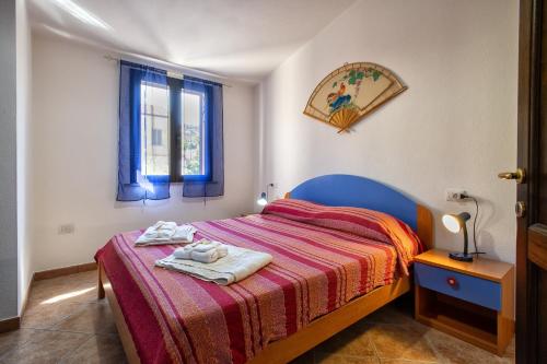 a bedroom with a bed with towels on it at Bilocale 1 medio Trinita' D'agultu in Trinità d'Agultu e Vignola