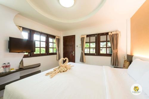 a bedroom with a white bed with a flat screen tv at Varin Beach Resort in Ko Lipe