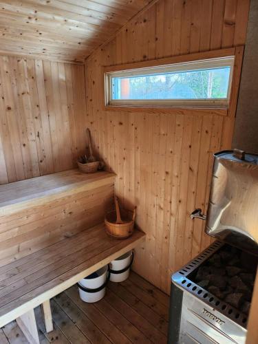 a wooden cabin with a bench and a stove at Stuga in Sävar