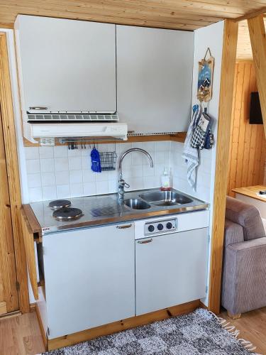 uma pequena cozinha com um lavatório e um fogão em Stuga em Sävar