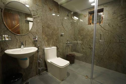 a bathroom with a toilet and a sink and a shower at Le Mistral, Kodai - Luxury Villa in Kodaikānāl