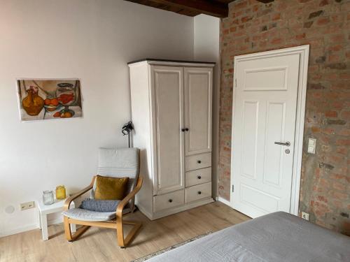 a bedroom with a bed and a chair and a cabinet at Mikroapartment Leipzig in Leipzig