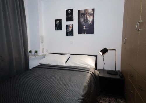 a bedroom with a bed and pictures on the wall at Studio Eleni in Plomari