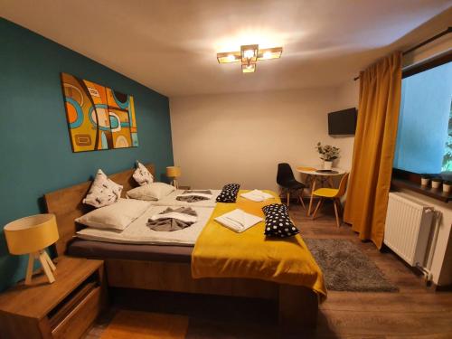 a bedroom with a bed with a yellow blanket on it at Laura Villa in Sovata
