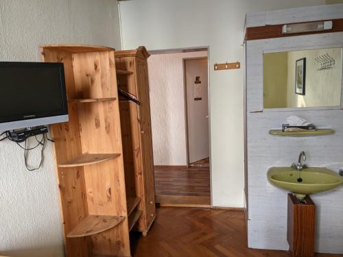 a bathroom with a sink and a tv on a wall at Monteurunterkunft Weiden by HausGruenerBaum in Weiden