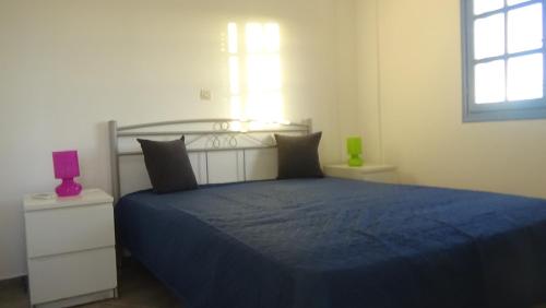 a bedroom with a blue bed and a window at Summer dream in Aliki