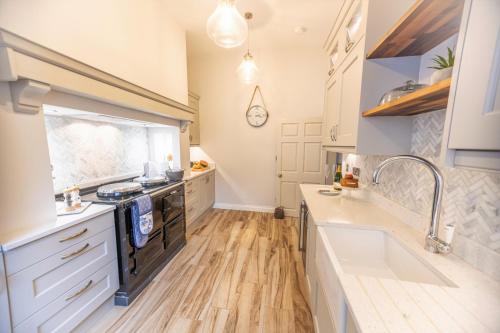 a kitchen with a sink and a stove top oven at Porte House - Holiday At Home in Richmond