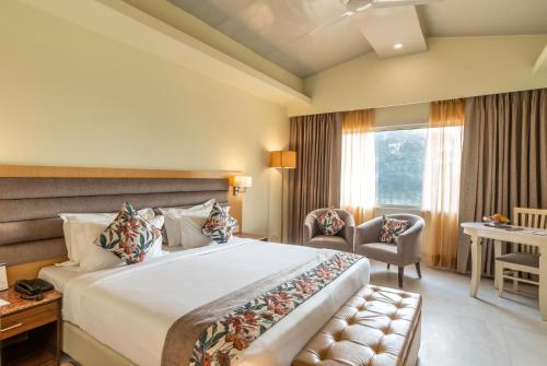 a hotel room with a large bed and a desk at Best Western Resort Country Club in Gurgaon